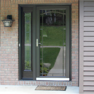 A home with brick exterior has a beautiful entryway with a glass storm door.